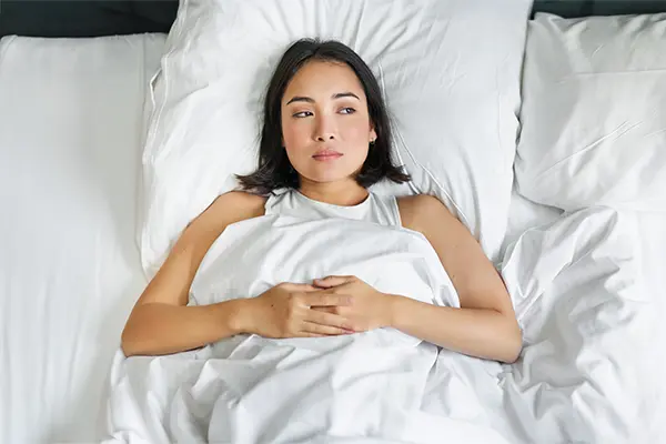 Woman lying awake in bed unable to sleep, representing insomnia clinical trials with nationwide access at Equity Medical