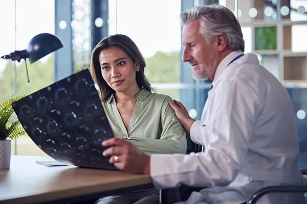 Doctor reviewing brain scan with patient during consultation for multiple sclerosis clinical trials across the US with Equity Medical
