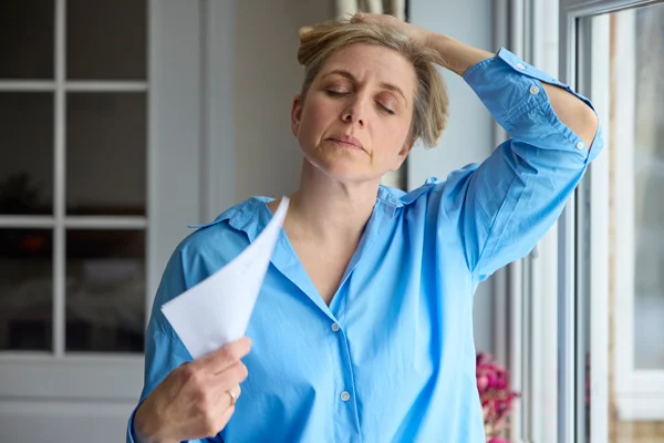 Woman experiencing menopause symptoms, an area of women’s health clinical trials at Equity Medical in Owensboro